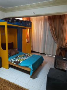 ein Schlafzimmer mit einem Etagenbett mit blauer Decke in der Unterkunft Apartment For Rent at Gamal Abdelnasser Street directly near from the sea in Alexandria