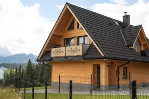 una casa de madera con techo negro en Dom z widokiem na góry i prywatnym jacuzzi w Zębie, en Ząb
