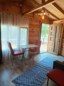 a dining room with a table and chairs and a rug at Eses Camping in Mugla