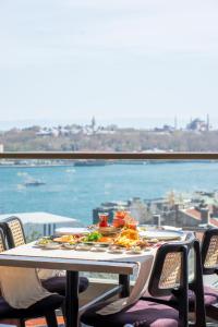 uma mesa com comida e vista para o oceano em Fragments Hotel em Istambul