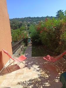 a couple of chairs sitting on a patio at Appartement avec piscine in Cavalaire-sur-Mer