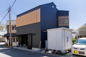 ein schwarzes Gebäude mit einer weißen Box davor in der Unterkunft 【Oyado街】宿泊者限定！貸切クルーザー・SUPツアー　別荘感覚で新築一軒家貸切ハウステンボス近く in Hayaki