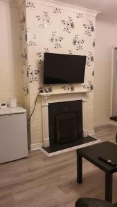 2 bedroom house, Tunstall, Stoke-on-Trent. في ستوك أون ترينت: غرفة معيشة مع موقد وتلفزيون بشاشة مسطحة