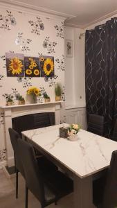 a dining room table with chairs and flowers on the wall at 2 bedroom house, Tunstall, Stoke-on-Trent. in Stoke on Trent