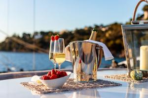 Nuit insolite à bord d'un Yacht في مارسيليا: طاولة مع كوب من النبيذ ووعاء من الفراولة