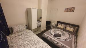 a small bedroom with a bed and a mirror at 2 bedroom house, Tunstall, Stoke-on-Trent. in Stoke on Trent