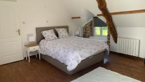 a bedroom with a bed and a table and a window at Gîte la belle etoile in Ver