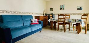 ein Wohnzimmer mit einem blauen Sofa und einem Tisch in der Unterkunft Une pause à Bénodet in Bénodet