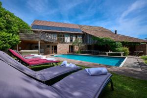 une maison avec une piscine et deux chaises longues dans l'établissement Pêche de Vigne & Spa, à Rodern