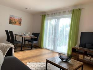 a living room with a tv and a table with chairs at Ferienwohnung Familie Eder in Schönberg