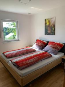 a bed with red pillows on it in a bedroom at Ferienwohnung Familie Eder in Schönberg