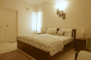 Luxre Homes - Villa in Koramangala في بانغالور: غرفة نوم بسرير ونافذة