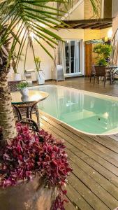 a pool with a table and a palm tree at La Plage Residence in Garopaba