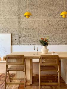 a wooden table with two chairs and a vase with flowers at VibesCoruña- Apartamento céntrico recién reformado in A Coruña