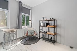 Zimmer mit einem Stuhl, einem Tisch und einem Regal in der Unterkunft Spacious Guest Suites near Historic Market - 5 Min Walk in Brügge