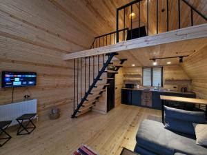 una sala de estar con una escalera en una casa de madera en Misty Rocks Kazbegi en Kazbegi