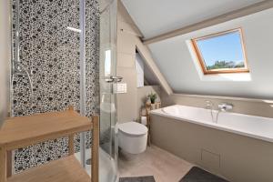 La salle de bains est pourvue d'une baignoire, de toilettes et d'une douche. dans l'établissement Spacious Guest Suites near Historic Market - 5 Min Walk, à Bruges