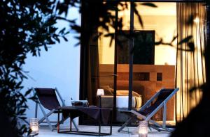 a patio with two chairs and a table and a bed at Masseria Le Fabriche in Maruggio