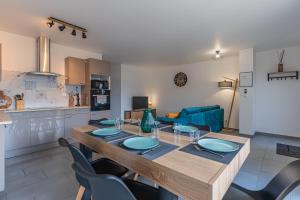 una cucina e una sala da pranzo con tavolo e sedie di La p'tite maison de Charlotte a Cissac-Médoc