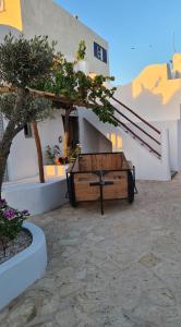 a bench in a courtyard with a tree and stairs at La Maison des Vagues in Sidi Kaouki