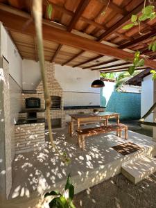 een patio met een houten tafel en een bank bij Casa Colonial Cabore in Paraty