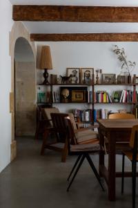 a living room with a table and chairs and a book shelf at la Perroya in Visan