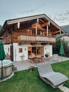a large wooden house with a deck and a patio at Chalet Nordic mit privatem Whirlpool und Sauna in Bayrischzell