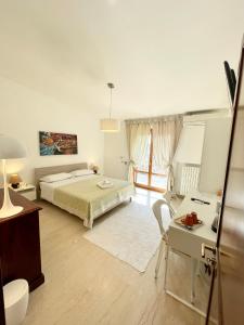 a bedroom with a bed and a table and a desk at B&B Le Saline in Taranto