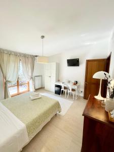a white bedroom with a bed and a table at B&B Le Saline in Taranto