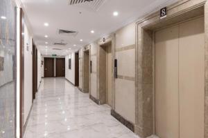 a hallway of a building with white tile floors at Snood Ajyad Hotel Tower 1 in Makkah