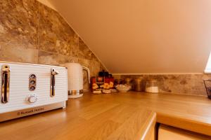 a kitchen with a white stove and a wooden floor at Combe Hill Apartments in Ilfracombe