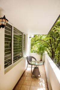 balcón con mesa, sillas y ventana en Luxre Homes - Villa in Koramangala, en Bangalore