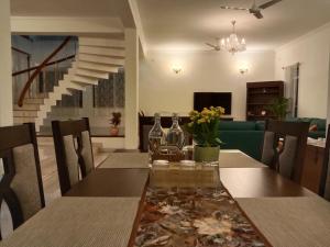 Luxre Homes - Villa in Koramangala في بانغالور: غرفة طعام مع طاولة وأريكة