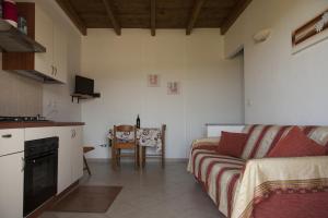 a kitchen and a living room with a couch and a table at Roccabianca in Sorso