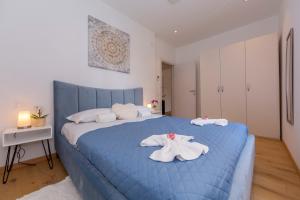 Un dormitorio con una cama azul con toallas. en Heart of Lugano - Happy Rentals, en Lugano