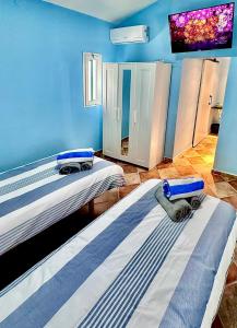 duas camas num quarto com uma televisão na parede em Casa-De-Golf em Alhaurín de la Torre