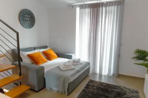 um quarto com uma cama com almofadas laranja e um relógio em Antiga adega em Óbidos