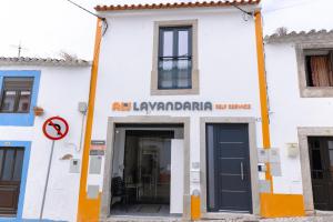 um edifício branco com um sinal que lê ar lavanderarma em Antiga adega em Óbidos