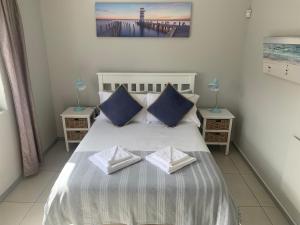 a bedroom with a large bed with two night stands at OysterCatcher Self-Catering Accommodation Strand in Cape Town