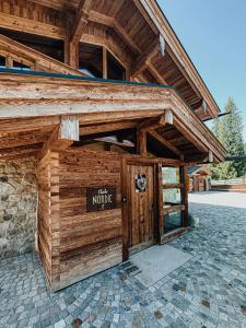 a wooden building with a sign on the door at Chalet Nordic mit privatem Whirlpool und Sauna in Bayrischzell