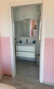 een badkamer met een wastafel en een spiegel bij Giroloft in Cagliari
