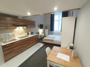 a kitchen and a bedroom with a bed and a table at TLC Apartments Cracow in Kraków