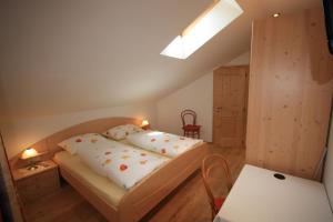 a small bedroom with a bed and a table at Haus Schmiedhofer in Villabassa