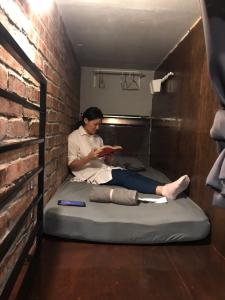 Eine Frau auf einem Bett in einem Zimmer in der Unterkunft OA ThE FACTORY AT BUKIT BINTANG in Kuala Lumpur