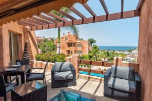 a patio with a table and chairs and a view of the ocean at Romen 2-2 PENTHOUSE SEA VIEW & JACUZZI 2B in Palm-mar