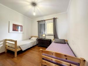 - une chambre avec 2 lits et une fenêtre dans l'établissement Reis Magos View, à Caniço