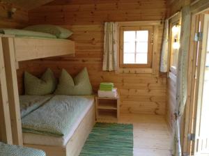 ein Schlafzimmer in einem Blockhaus mit Etagenbetten in der Unterkunft Radlerstation-Sandhof in Berg im Drautal