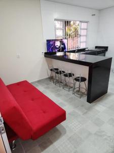 salon z czerwoną kanapą i barem w obiekcie Casa Represa Furnas c/ Piscina Aquecida w mieście Alfenas