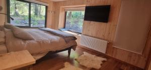 a bedroom with a bed and a large window at Refugio PIREN, Corralco, Hot Tub y nieve in Curacautín