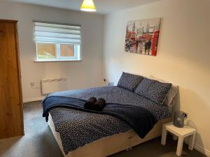 a bedroom with a bed with a blue blanket and a window at May Disc - Long Stay - Contractors in Bristol